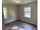 A comfortable bedroom features hard surface floors, neutral colored walls, and sun-filled window at 633 Tom Read Dr, Marietta, GA 30062