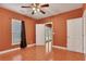 Bedroom features tile flooring, a ceiling fan, a window, and three doors at 3704 Ramsey Sw Cir, Atlanta, GA 30331