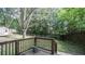 View from the wooden deck of a wooded backyard and tool shed, with a split rail fence and a privacy fence at 4443 Toonigh Nw Rd, Acworth, GA 30101