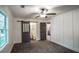 Bedroom featuring neutral carpet, sliding barn door to bath, and paneled accent wall at 4443 Toonigh Nw Rd, Acworth, GA 30101