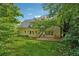 Large backyard with luscious green grass, shade trees, and a brick patio space at 5013 Kendall Nw Sta, Acworth, GA 30102