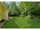 Large backyard with luscious green grass, brick patio, and shade trees creating a private space at 5013 Kendall Nw Sta, Acworth, GA 30102
