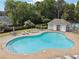 A community pool features lounge chairs, tables, and a nearby clubhouse and tennis court surrounded by mature trees at 5013 Kendall Nw Sta, Acworth, GA 30102