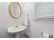 Small powder room with pedestal sink, gold mirror, and window with closed blinds at 5013 Kendall Nw Sta, Acworth, GA 30102