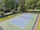 An aerial shot of a well-maintained tennis court with net, surrounded by green foliage and a partial view of nearby homes at 5013 Kendall Nw Sta, Acworth, GA 30102