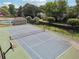 Aerial view of the community tennis court with basketball hoop, pool and bath house, surrounded by lush trees at 5013 Kendall Nw Sta, Acworth, GA 30102