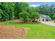 Landscaped backyard featuring a swing set and spacious lawn and three-car garage at 590 Arthur Rd, Canton, GA 30115