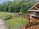 Backyard view of a wooden deck overlooking a lush landscaped backyard with pond and stone waterfall feature at 590 Arthur Rd, Canton, GA 30115