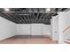 Unfinished basement with wood-look floors, painted ceiling, and staircase at 590 Arthur Rd, Canton, GA 30115