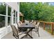 Outdoor deck featuring a large dining table and chairs overlooking lush greenery, perfect for entertaining at 590 Arthur Rd, Canton, GA 30115