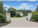 Long driveway leading to a beautiful home with manicured landscaping and a classic white exterior at 590 Arthur Rd, Canton, GA 30115