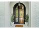 Grand entrance featuring an ornate wrought iron door, brick archway, and a glimpse of the home's interior at 590 Arthur Rd, Canton, GA 30115