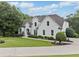 Stately white home with a well-manicured lawn and mature trees, offering a serene setting at 590 Arthur Rd, Canton, GA 30115
