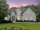 Elegant two-story white brick home with manicured landscaping, a dark roof and arched entryway at 590 Arthur Rd, Canton, GA 30115