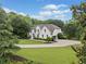 Charming white home nestled on a large lot with a meticulously landscaped yard and mature trees at 590 Arthur Rd, Canton, GA 30115