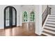 The foyer features arched windows, an iron door, a chandelier, hardwood floors and a staircase at 590 Arthur Rd, Canton, GA 30115