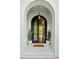 Elegant arched front door with custom ironwork and manicured potted plants on a brick porch at 590 Arthur Rd, Canton, GA 30115