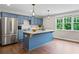 Charming kitchen with blue cabinets, stainless steel appliances, granite countertops, and hardwood flooring at 590 Arthur Rd, Canton, GA 30115