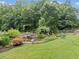 Serene backyard featuring a rock pond and lush greenery with a swing at 590 Arthur Rd, Canton, GA 30115