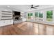 Living room featuring a stone fireplace, built-in shelving, hardwood flooring and bright windows at 590 Arthur Rd, Canton, GA 30115