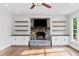 Bright living room with a stone fireplace, floating shelves, and hardwood floors at 590 Arthur Rd, Canton, GA 30115