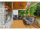 Inviting covered porch featuring stone fireplace and comfortable seating, perfect for enjoying the outdoors at 590 Arthur Rd, Canton, GA 30115
