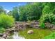 Scenic view of the backyard pond with cascading waterfalls and diverse plants at 590 Arthur Rd, Canton, GA 30115
