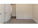 A simple bedroom offers neutral walls and plush carpet flooring, transitioning into wood flooring visible through the doorway at 933 Capitol View Nw Ave, Atlanta, GA 30318