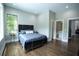 Bedroom features a large window offering views of the outdoors, dark wood floors, and an attached bathroom at 1099 Vista Ne Trl, Atlanta, GA 30324