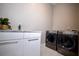 Modern laundry room features white cabinets, marble countertop, stainless steel faucet, and newer front-loading washer and dryer at 1099 Vista Ne Trl, Atlanta, GA 30324