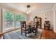 Sunlit dining room features a round table with wooden chairs and a large window overlooking the landscaped yard at 1652 Tryon Ne Rd, Atlanta, GA 30319