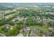 An aerial view showcasing the house nestled amongst trees and lush green landscaping, including a serene backyard pond at 2623 Lindsey Grace Ln, Buford, GA 30519