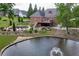 Picturesque backyard featuring a relaxing pond with fountain and pool area, adjacent to a sprawling deck and lush landscaping at 2623 Lindsey Grace Ln, Buford, GA 30519