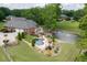 Beautiful backyard featuring a swimming pool, pond with fountain, patio, mature trees, and lush landscaping at 2623 Lindsey Grace Ln, Buford, GA 30519