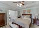 Cozy bedroom with tray ceiling, ceiling fan, and ensuite bathroom access at 2623 Lindsey Grace Ln, Buford, GA 30519