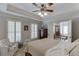 Relaxing bedroom featuring a tray ceiling and chair with ensuite bathroom access at 2623 Lindsey Grace Ln, Buford, GA 30519