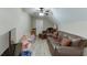 Cozy bonus room features a leather couch, ceiling fan, wood floors and natural light at 2623 Lindsey Grace Ln, Buford, GA 30519