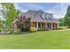 Brick home with a manicured lawn and mature trees offers a picturesque and serene setting at 2623 Lindsey Grace Ln, Buford, GA 30519
