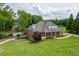 Beautiful two-story brick home with a well-manicured lawn, mature trees, and circular driveway at 2623 Lindsey Grace Ln, Buford, GA 30519
