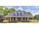 Charming brick home with a covered front porch, black shutters, and landscaped bushes enhancing its traditional appeal at 2623 Lindsey Grace Ln, Buford, GA 30519