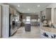 A large open kitchen featuring gray cabinetry, stainless steel appliances, and wood flooring at 2623 Lindsey Grace Ln, Buford, GA 30519