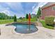 Inviting pool area with stone accents, an umbrella, and lush landscaping beside the back of the house at 2623 Lindsey Grace Ln, Buford, GA 30519