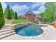 A beautiful kidney-shaped pool is surrounded by stone accents, complemented by a deck and well-maintained landscaping at 2623 Lindsey Grace Ln, Buford, GA 30519