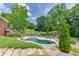 Beautiful backyard featuring a kidney-shaped pool, stone patio, and mature landscaping near exterior of home at 2623 Lindsey Grace Ln, Buford, GA 30519