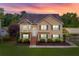 Inviting two-story home featuring a well-maintained lawn, manicured bushes, and classic curb appeal at twilight at 638 Oberlochen Way, Douglasville, GA 30134