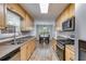 Galley kitchen with stainless steel appliances and light wood cabinets overlooking breakfast nook at 638 Oberlochen Way, Douglasville, GA 30134