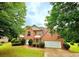 Charming two-story brick home featuring a manicured lawn, attached garage, and mature trees at 759 Hennepin Ter, Mcdonough, GA 30253