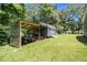 View of the back yard featuring a corrugated outbuilding next to a storage shed at 130 Driver St, Temple, GA 30179