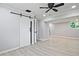 Finished basement with sliding barn door, ceiling fan, and light, wood-look flooring at 1349 Heather Cir, Riverdale, GA 30296