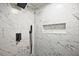 Close-up of remodeled shower featuring mosaic flooring, marble-style tiles and a shower niche at 1349 Heather Cir, Riverdale, GA 30296